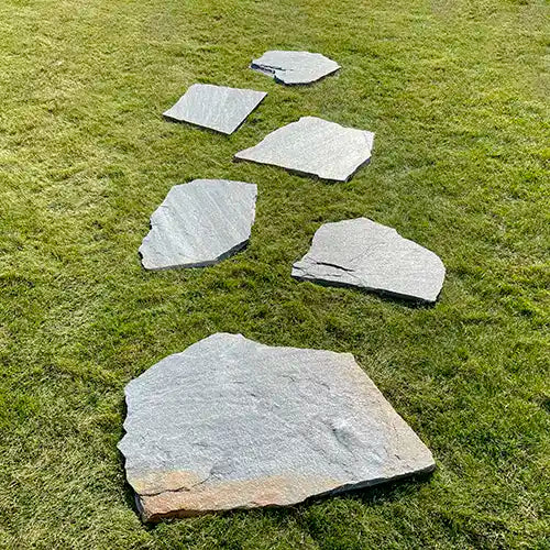 Quarzit Deep Sea Trittplatten als Gartenweg auf der Wiese verlegt. Verlege Variante: Parallel versetzt