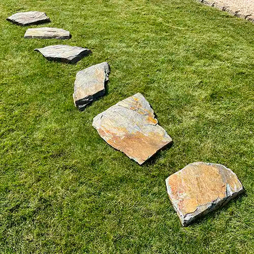 Lineare Verlegung von Grauwacke Trittplatten auf der Wiese