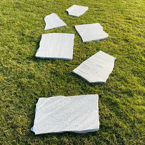 Polaris Quarzit Trittplatten auf der Wiese parallel versetzt verlegt