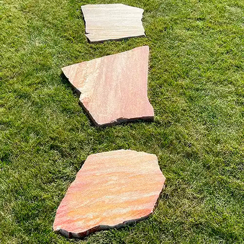 Gartenweg aus Antares Quarzit Trittplatten, linear auf dem Rasen verlegt.
