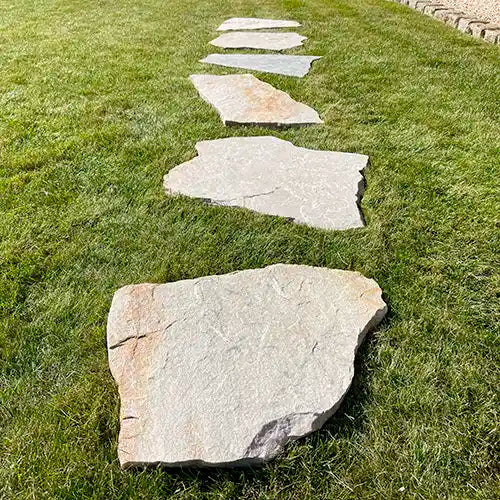 Beispiel lineare Verlegung von Quarzit Clara Trittplatten auf der Wiese