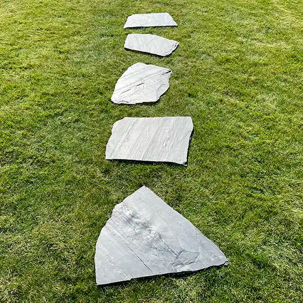 Lineare Verlegung der Trittplatten Schiefer Negra auf dem Rasen