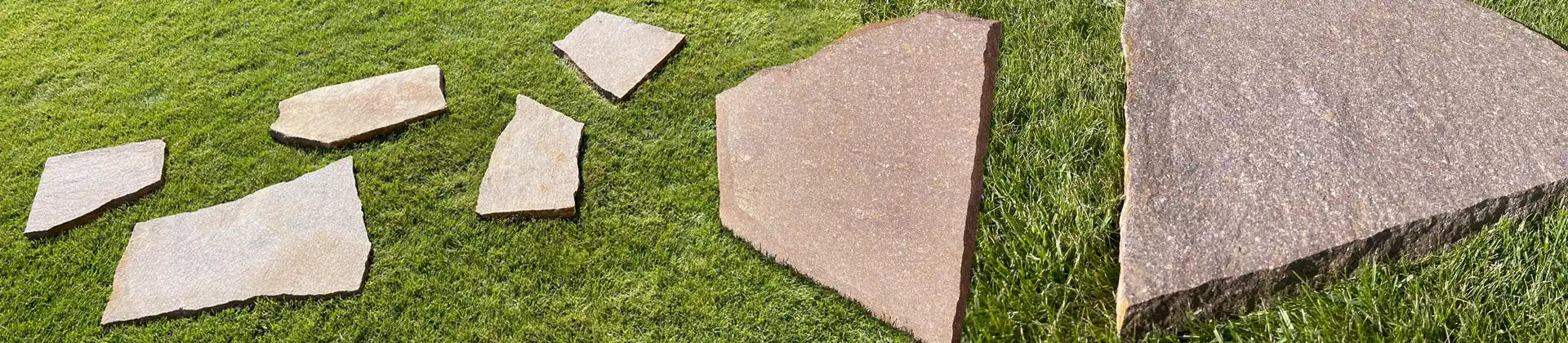 Verschiedene Porphyr Trittplatten als Beispiel auf dem Rasen