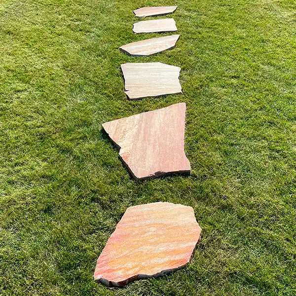 Gartenweg aus Antares Quarzit Trittplatten. Lineare Verlegung auf dem Rasen.
