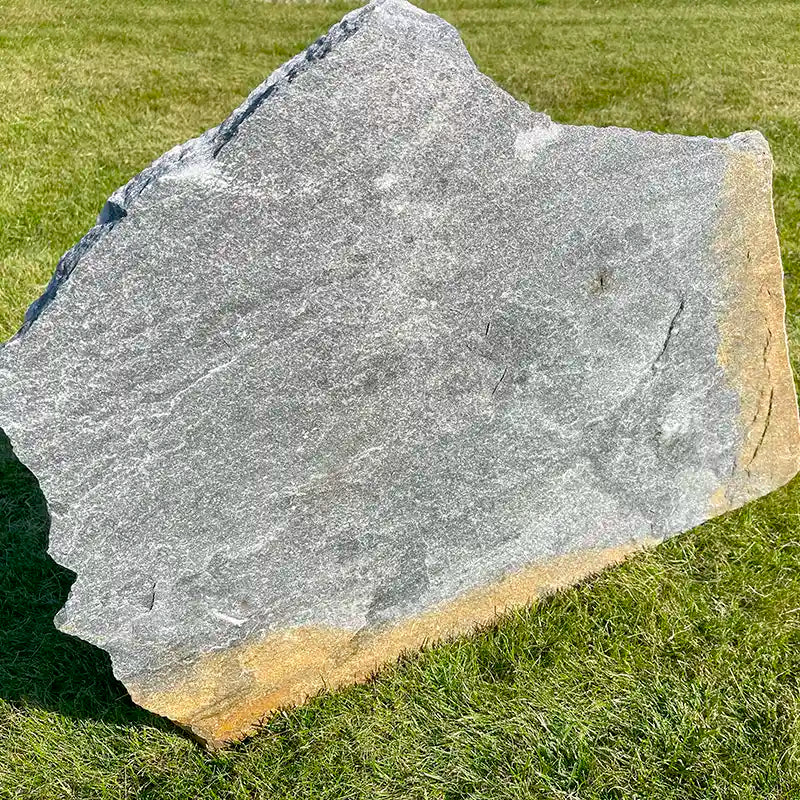 Beispiel: Trittplatte aus Quarzit-Stein "Deep Sea" im Sonnenlicht auf der Wiese