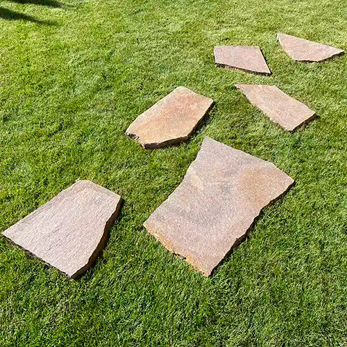 Beispiel einer parallel versetzten Verlegung von Porphyr Trittplatten auf dem Rasen
